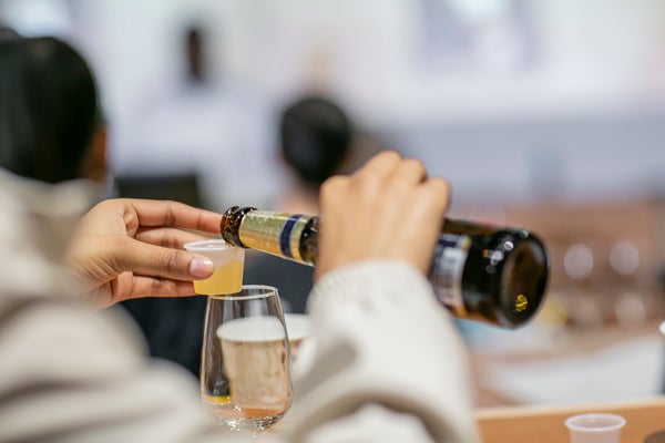 A student pours a measured sample of beer in Miller