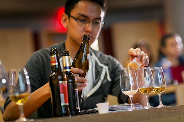 A student pours a sample of beer in class.