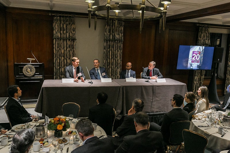 Panelists address the group from behind a table