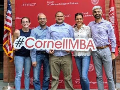 Five MBA students pose for a photo