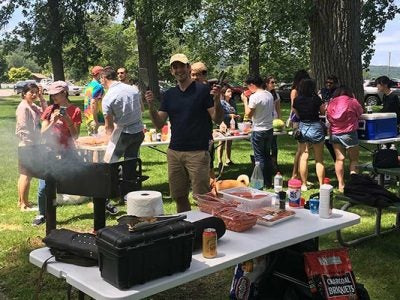 Nathan Ladovsky, MMH ’18, cooking hamburgers and hot dogs at Stewart Park