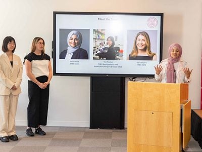 Eman Said, Rui Huang, and Kara Styers stand at the front of the room pitching at the Life Sciences Technology Innovation Fellowship Showcase.