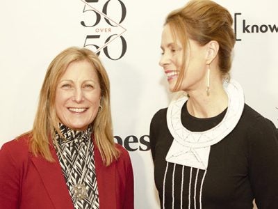 two women standing next to each other and smiling.