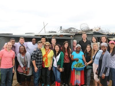 Our group of Dyson students and professors, as well as Emzingo staff in South Africa, visiting with the owner of a spaza shop to learn about her business.