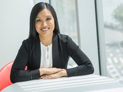 Maggie Chan Jones,MBA ’09, founder and CEO of Tenshey, seated in a red chair at a white table