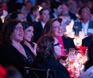 Mia Kyricos, MMH &lsquo;03, sites at a festively decorated table during the awards ceremony.