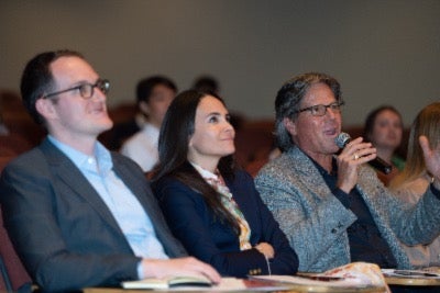 Competition judge Chris Hemmeter &rsquo;86, seated next to Zach Demuth, MMH &rsquo;16 and Gilda Perez-Alvarado &rsquo;02, speaks into a microphone.