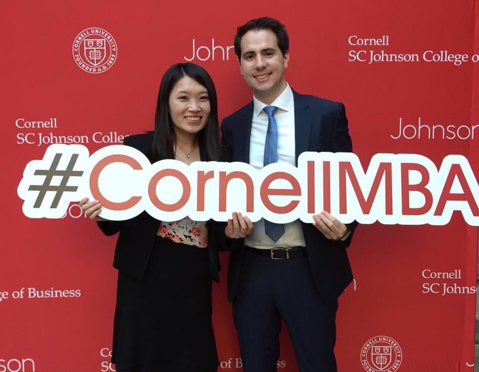 Photo of Nan and Nicolas holding a #CornellMBA sign