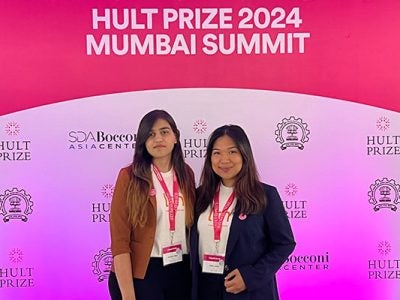 Two women standing side by side in front of a backdrop with the text: Hult Prize and SDA Bocconi Asia Center.
