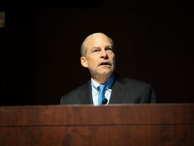 A man standing behind a podium and speaking.