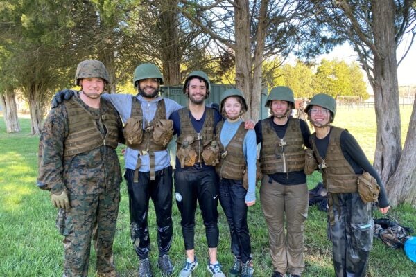 Cornell MBA students pose in military type attire with US Marines in Quantico as part of an excursion