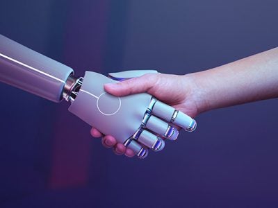 An image of a robot hand shaking the hand of a human.