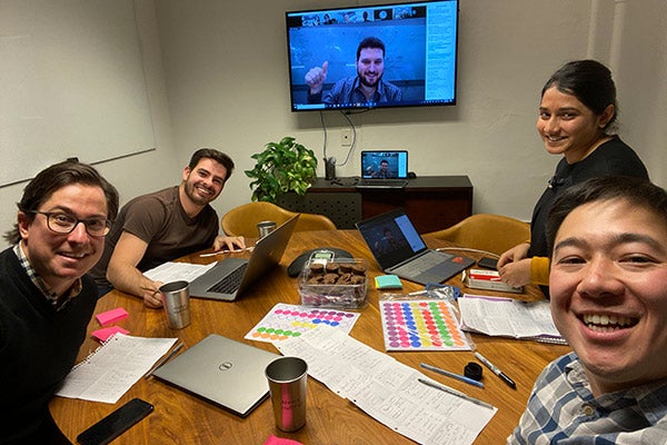 Samuel Cho working at a table with with 3 other people in a breakout room and another person on screen.