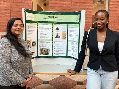 A picture of Shivani Mulji and Femi Olonilua in front of a poster board in Sage Hall.