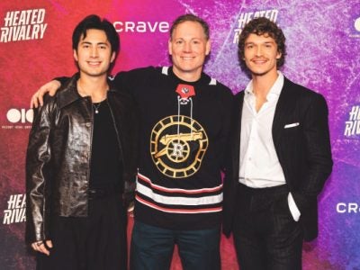 Stockman (center) with the stars of “Heated Rivalry,” Hudson Williams (left) and Connor Storrie. Stockman is wearing the jersey of the show’s fictional Boston Raiders