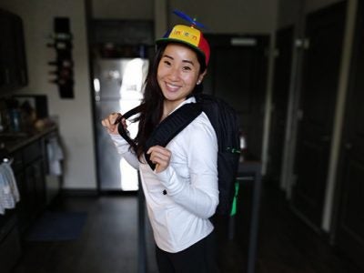 photo of Taylor Nguyen wearing a Google cap and smiling, standing in her kitchen
