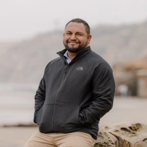 Teevrat Garg stands on a beach on an overcast day.