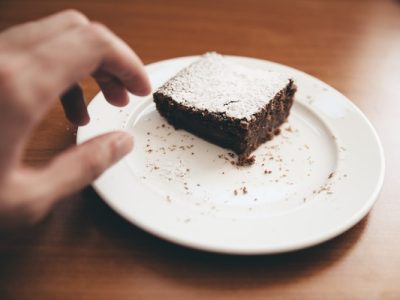 Hand reaching for brownie dessert