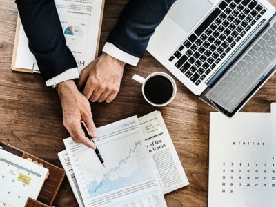 Man working at a computer and pointing to a chart