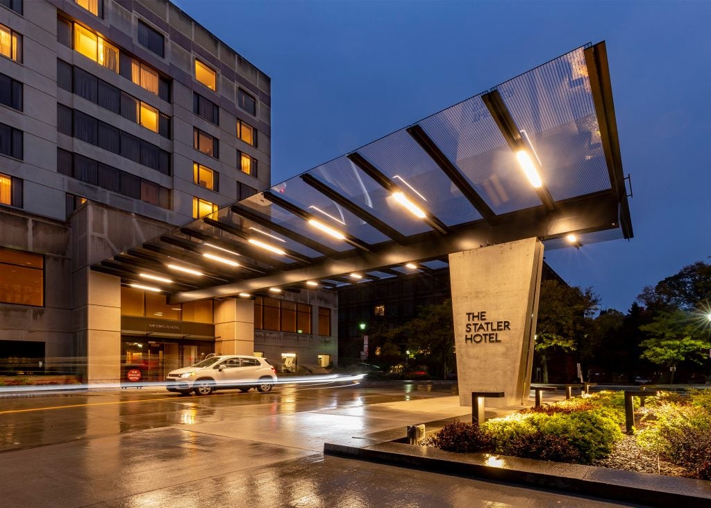 The front entrance of the Cornell Statler Hotel at night, softly illuminated with exterior lighting.