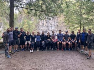 Photo of a large group with the Treman waterfall behind them