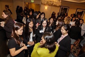 Amy Tran and Clair Pen with other students talking to a finance expert.