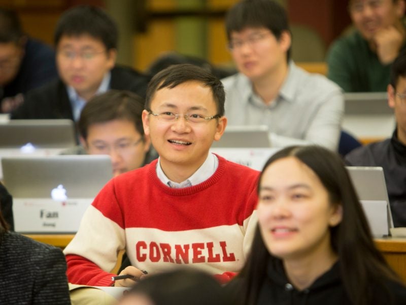 Several students attend a class in a lecture hall in Beijing as part of the Cornell-Tsinghua Finance MBA program