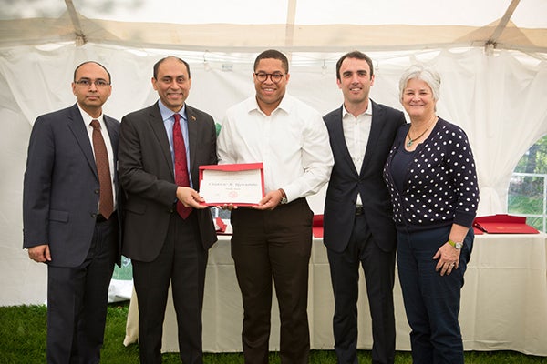 Photo of Chidozie Ugwumba, MBA &rsquo;15 (center), is presented with the Finance Award in 2015 for demonstrating outstanding scholarship in finance