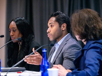 Van Hamilton Barbeau '11, MS/MBA '20 on stage with two panelists speaking