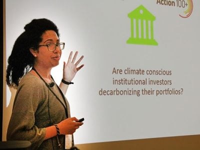 A female professor addresses a group in a lecture hall.