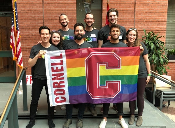 2019 O4B leadership team with Cornell Pride flag at the Out for Business Pride! Sage Social.