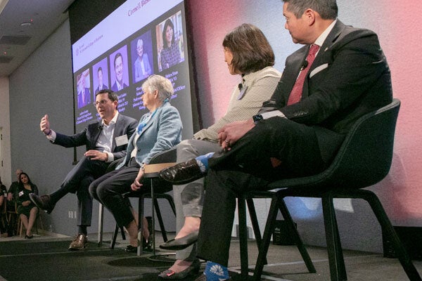 Photo of four panelists on stage at the Cornell Business Forum.