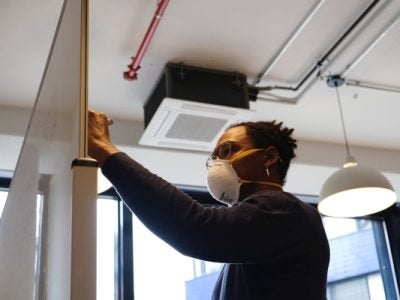 Masked HR person makes a list on a white board