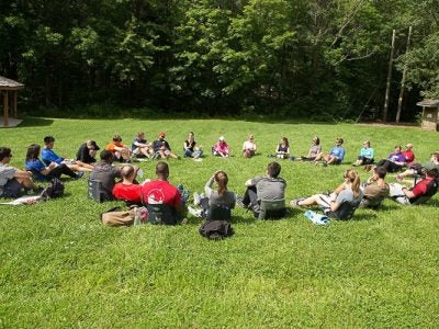 Students sitting in on circle in a field