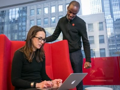 Two students look at a laptop