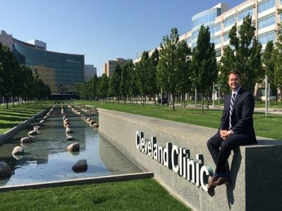 Andre sitting on a wall that says Cleveland Clinic