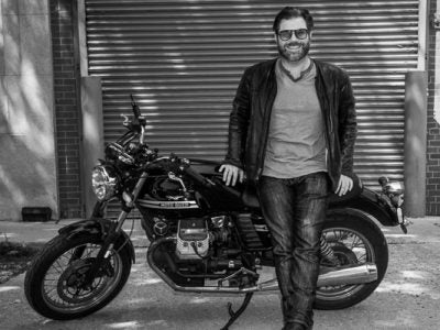 Austin Rothbard leaning against a motorcycle