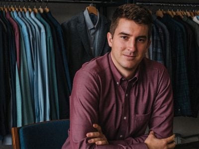 Image of Mac Bishop in front of his clothing line made out of merino wool