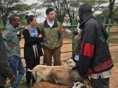 Photo of a group talking to Kenyans with sheep