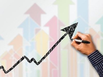 A man draws an upward profit arrow on a whiteboard