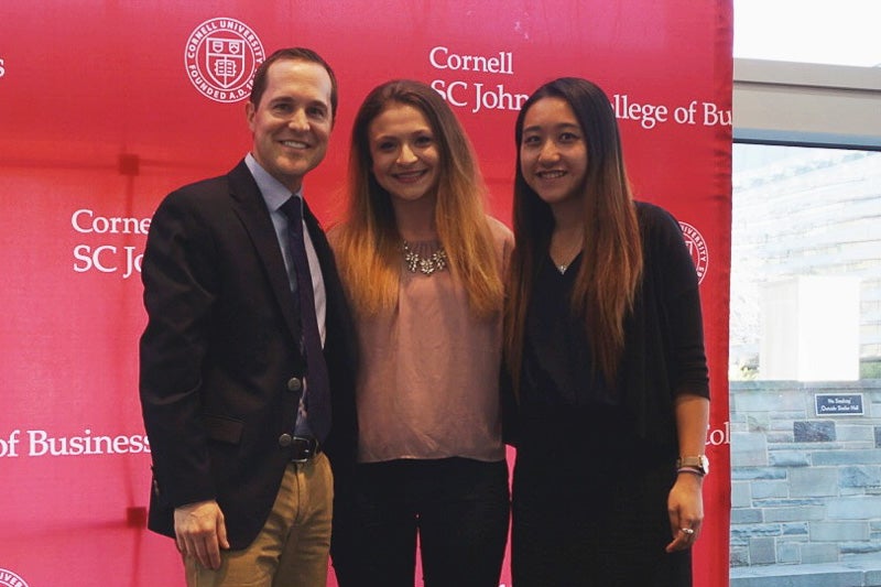 Photo of Andrew, Alexa, and Christie in front of a red backdrop
