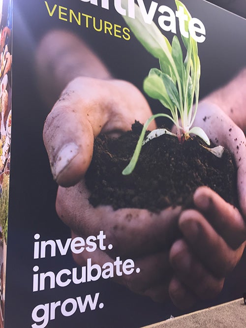 Photo of a booth that says invest. incubate. grow.