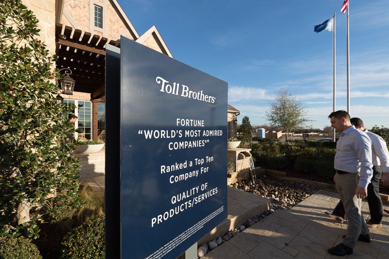 Photo of people entering a building that says Toll Brothers, Fortune 