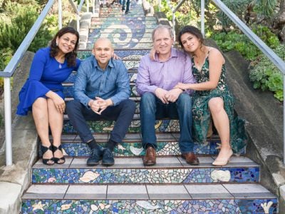 Photo of Diana with her son, husband, and daughter sitting on a staircase