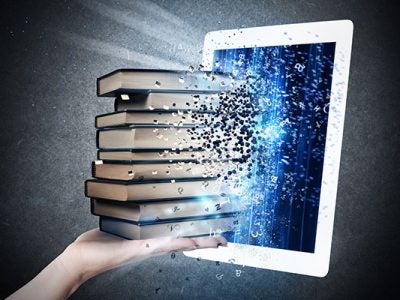 photo illustration of a hands feeding physical books into a digital screen.