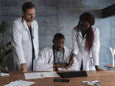Three physicians gathered around a desk