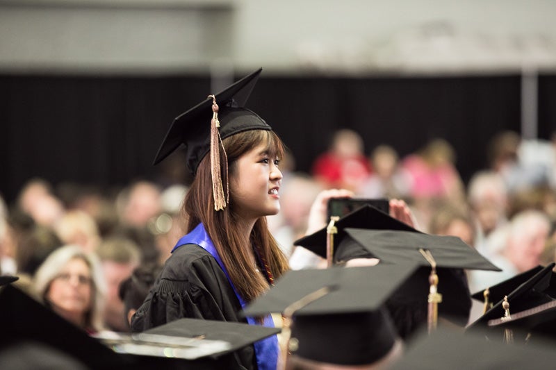 Photo of graduate standing among others