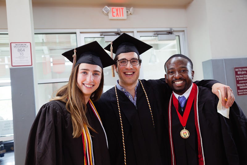 Photo of three graduates in their gowns