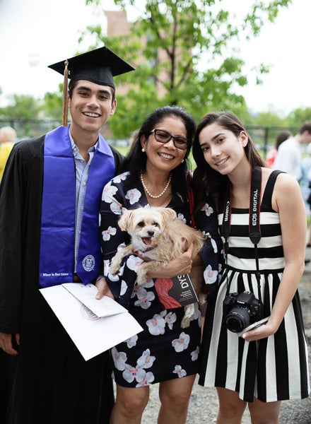 Photo of a graduate with his family and dog
