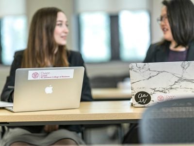 Photo of two women with their laptops